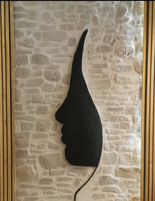 Sculpture murale contemporaine intégrée dans un décor en imitation pierre avec éclairage architectural réalisée par MTG Création à Paris 8e arrondissement (75008).